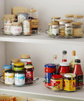 Two Pack 9.25 Inch Lazy Susan Organizer Turntable for cabinets tables pantries and refrigerators displaying jars and bottles.