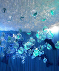 Decorative blue-lit ceiling arrangement with 20 Pack 4-Inch Clear Plastic Fillable Ornaments Ball for Christmas, Wedding, Party, Home Decor.