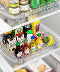 Clear Rectangular Refrigerator Lazy Susan Organizer With 360 Degree Rotation And Pullout Design for storing bottles, cans, and produce.