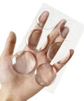 Hand holding 6 Pack Clear Door Stopper Wall Protectors, 2 Inch Round Self Adhesive Cushions, Transparent Wall Shield Bumpers For Door Handles