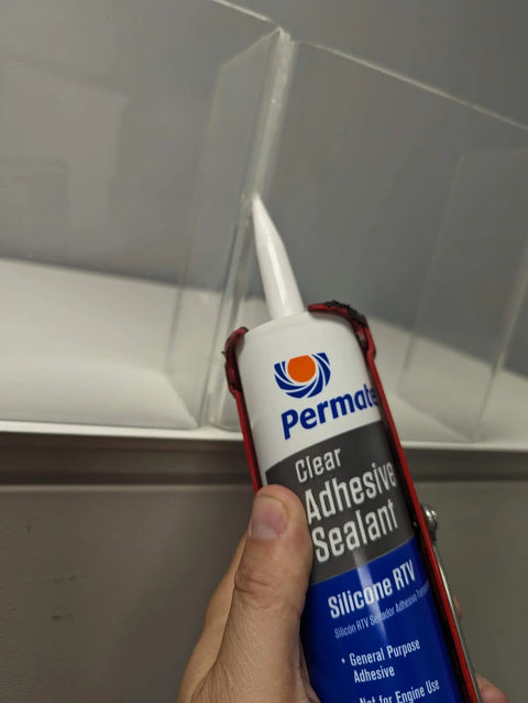 Clear RTV Silicone Adhesive Sealant for Indoor and Outdoor Use, Waterproof, 11 Oz Tube, being applied to a surface.