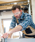 Man wearing Clear ANSI Z87.1 Safety Eyewear For Men And Women Scratch Resistant Lenses while working in workshop