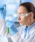 Scientist wearing 48 Pack Safety Glasses Clear Protective Eyewear For Work Lab Lightweight Comfort while conducting an experiment.