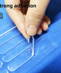 Person peeling Clear Self Adhesive Door Silencers Long Strips Ultra Quiet Rubber Cabinet Bumpers from blue backing sheet.