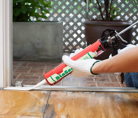 Applying Waterproof 100 Percent Silicone Caulk And Sealant For Bathrooms And Kitchens, 10 Oz Cartridge, clear, on a doorframe