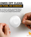 Person removing Ducki wall protector from surface using dental floss