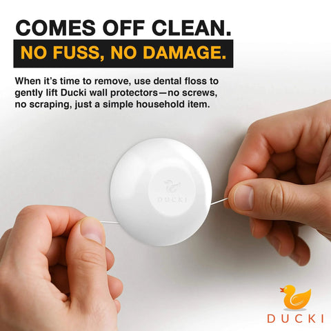 Person removing Ducki wall protector from surface using dental floss