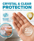 Person holding 2-inch clear STRONGEST HOME Wall Protector for Door Knobs, showing its flexible, durable rubber material.