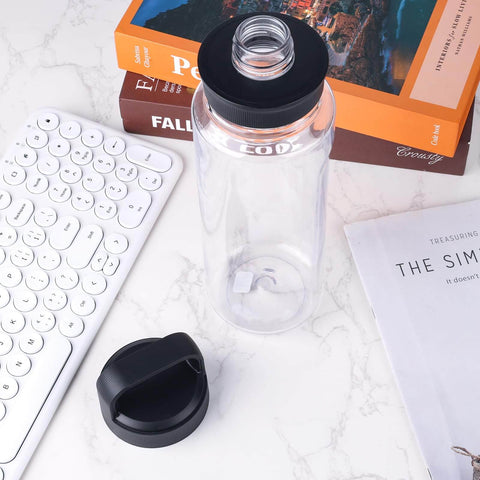 Clear water bottle on desk with black lid detached, showcasing 4 Pack Silicone Gasket Replacements For Yonder Water Bottles 20 Oz 25 Oz 34 Oz And 50 Oz Leak Proof O Ring Seals Silicone Sealing Rings Tumbler Lid Replacement Parts BPA Free Includes Removal Hook