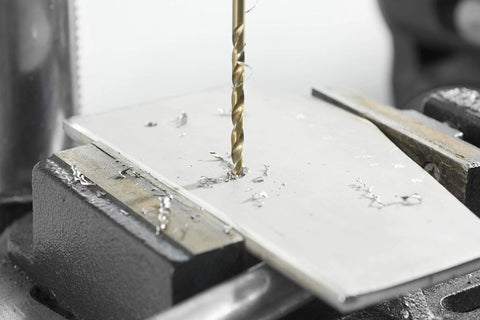 Bosch 14-Piece Cobalt M42 Drill Bit Set in action, drilling through a metal sheet, showcasing durability and precision use on stainless steel.