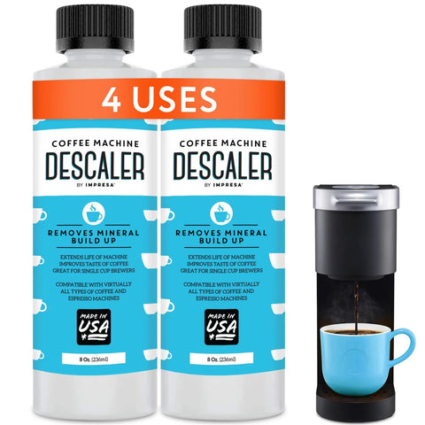 Two Pack Universal Coffee Descaler For All Machines Including Keurig Nespresso Delonghi And Other Single Serve Coffee And Espresso Makers Made In USA 8 Oz Bottles Providing Four Descale Sessions To Remove Mineral Buildup And Residue next to coffee maker with cup.