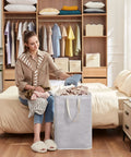 Woman using two pack large collapsible laundry hampers 80L each freestanding waterproof interior foldable laundry baskets with easy carry handles