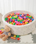 Ball Pit Balls for Kids -Pack of 150 Colorful Ball Pit Balls Crush Proof Plastic Toy Balls in a toddler play area with teddy bear