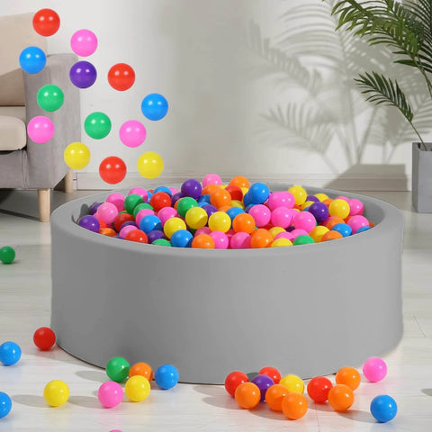 Colorful BPA-free plastic balls for ball pit in living room setting, 100pcs 2.2" set for toddlers, seven vibrant colors.