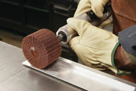 Worker using Combi S Wheel P180 Grit Aluminum Oxide with X Weight Backing on die grinder for metal finishing.