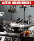 Professional kitchen setup with various utensils, including pans, whisks, ladles, and bowls on a stainless steel counter.