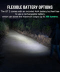 Person using ultra compact EDC flashlight on path, showcasing 200 lumens with 62 meter beam, ideal for camping and hiking.