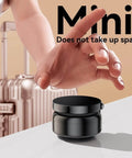 Hand reaching for mini Magnetic Phone Holder With Vacuum Grip Technology on surface, luggage in background.