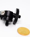 Compact Mini Ball Head Tripod Mount with 1/4 inch screw, black aluminum, seen with coin for scale, supports 360 degree rotation.
