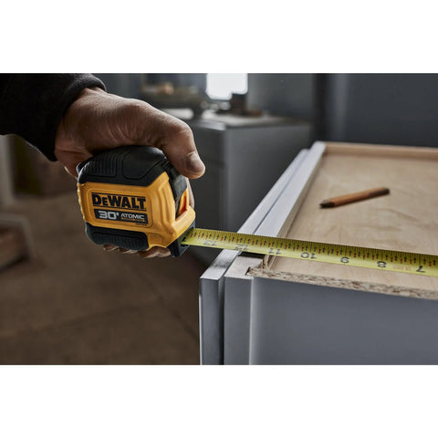 Atomic Compact 30 Ft Tape Measure With Finger Brake For Precision And One Hand Quick Measurement in use on job site