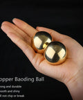 Hand holding Tianigo Copper Baoding Balls Set, 1.57 Inches Chinese Health Balls, stress relief hand massage balls for therapy.