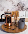 Acacia wood lazy susan organizer designed for kitchen and pantry use, rotating wooden turntable with coffee press and cups.