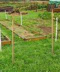 Grounding Rod Kit Zonon With Five Eighth Inch Copper Clad Grounding Rods And Clamps For Electric Fences installed in a garden.