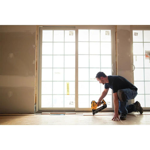 Cordless 15 Gauge Angled Finish Nailer 20V Max XR Renewed For Trim Molding Baseboards Crown Casing And Cabinetry Installation With Brushless Motor Long Lasting Battery And Dual Range Depth Control For Precise Fewer Nicks And Quick Clean Finish Work being used by a person installing molding near a window