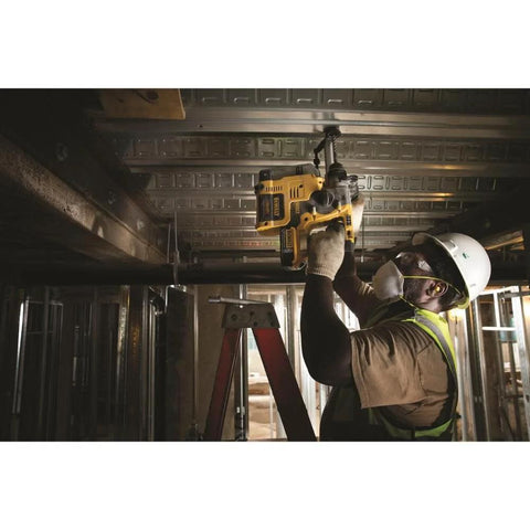 Construction worker using a compact 20V MAX SDS rotary hammer with brushless motor for overhead drilling in a building site.