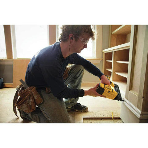 Carpenter using DEWALT 20V MAX cordless 18GA brad nailer kit with brushless motor and LED work light on trim project