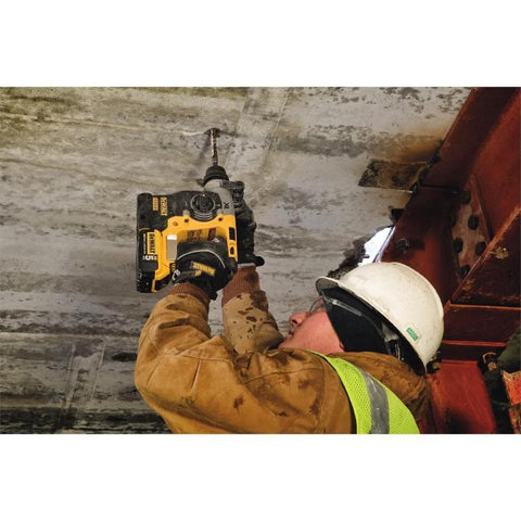 Worker using a compact 20V MAX SDS rotary hammer with brushless motor for overhead concrete drilling.