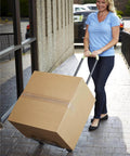 Woman using ✝️ COSCO Shifter Multi-Position Folding Hand Truck and Cart, 300 lb. Weight Capacity, Green, 12222PBG1E to move a large box