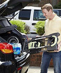 Person loading COSCO Shifter Multi-Position Folding Hand Truck and Cart, 300 lb. Weight Capacity, Green, 12222PBG1E into car trunk.