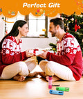 Couple exchanging gifts wearing matching sweaters next to Christmas tree with three pack glow in the dark aluminum mini flashlights.