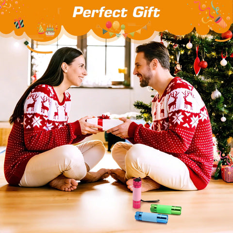 Couple exchanging gifts wearing matching sweaters next to Christmas tree with three pack glow in the dark aluminum mini flashlights.