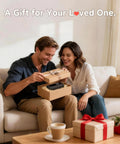 Couple opening gift box on sofa with cordless tire inflator portable air compressor inside, coffee table in foreground.