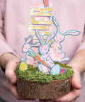 Decorative Easter centerpiece with rabbits, carrots, and Alphanumeric Emporium Thinlits Die Set 41PK crafted letters on wood slice.