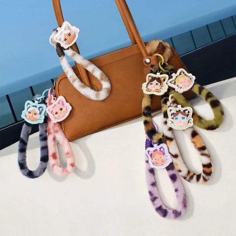 Crybaby Wild But Cutie Series phone charm blind box wrist straps in multiple colors attached to a handbag, PVC/ABS/nylon materials.