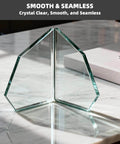 Geometric clear glass sculpture on marble table under sunlight