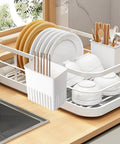Cutlery Drying Rack - Utensil Drainer - Cutlery Drainer for Sink holding dishes and utensils on a kitchen countertop next to a sink.