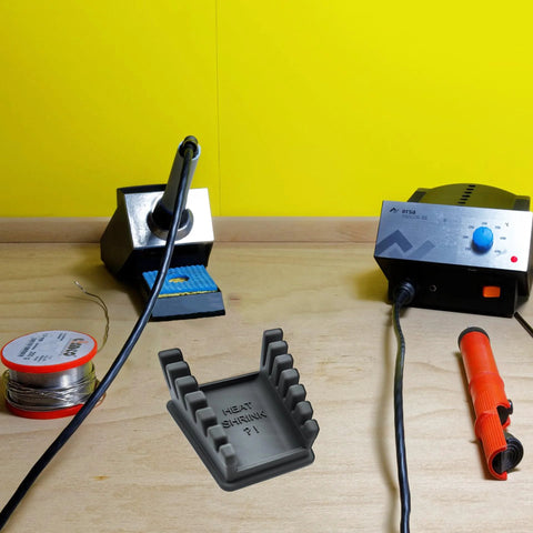 Upgraded Silicone Soldering Stand with six slot wire holder for 32AWG to 12AWG wires on workbench, dark grey, heat shrink reminder