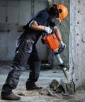 Worker using heavy duty 2200W demolition jack hammer delivers powerful 66J impact energy and 1350 BPM for fast concrete breaking