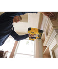 Person using DEWALT 20V MAX cordless 18GA brad nailer kit with adjustable depth on indoor trim project