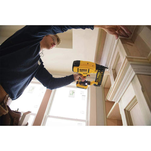 Person using DEWALT 20V MAX cordless 18GA brad nailer kit with adjustable depth on indoor trim project
