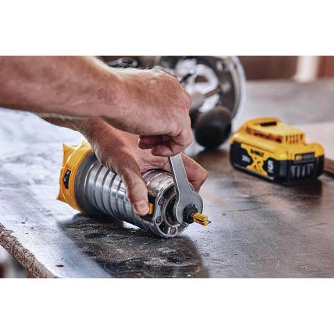 User adjusting 20V Max XR Cordless Brushless Router With Variable Speed Dual LEDs And Precise Depth Adjustment on workbench.