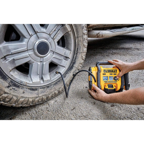Person using DEWALT Tire Inflator Portable Air Compressor 20V MAX, Car Air Pump with Automatic Shut Off on a car tire