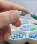 Diamond Tipped Bead Reamer Set For Jewelry Making With Color Coded Plastic Handles A Four Piece Steel Diamond Drill Kit To Enlarge Holes And Smooth Edges The Beadsmith close-up view of tool in use on a bead, showing detail of drill tip.
