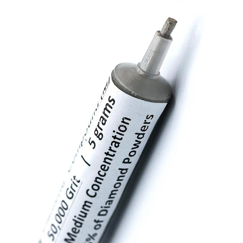 Close-up of a syringe labeled 50,000 grit, oil based diamond polishing paste with 25 percent diamond powder for precision finish.