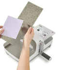 All In One 6 Inch Die Cutting And Embossing Machine Starter Kit For Crafters Includes Cutting Dies Embossing Folder Cardstock And Accessory Pack Compatible With Sizzix Big Shot For Scrapbooking And DIY Card Making showing die insertion