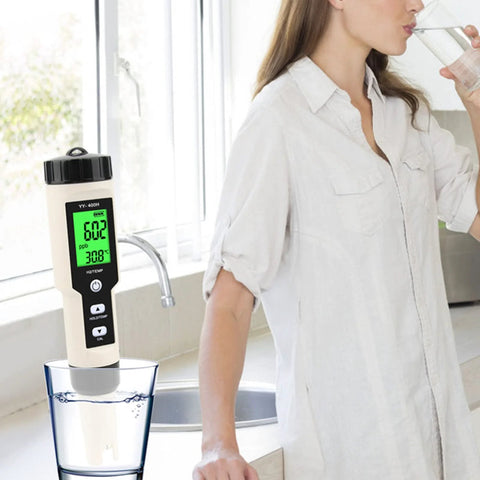 Digital Hydrogen Meter Water Quality Tester with ATC and Data Hold Function measuring water in a glass beside a woman drinking.